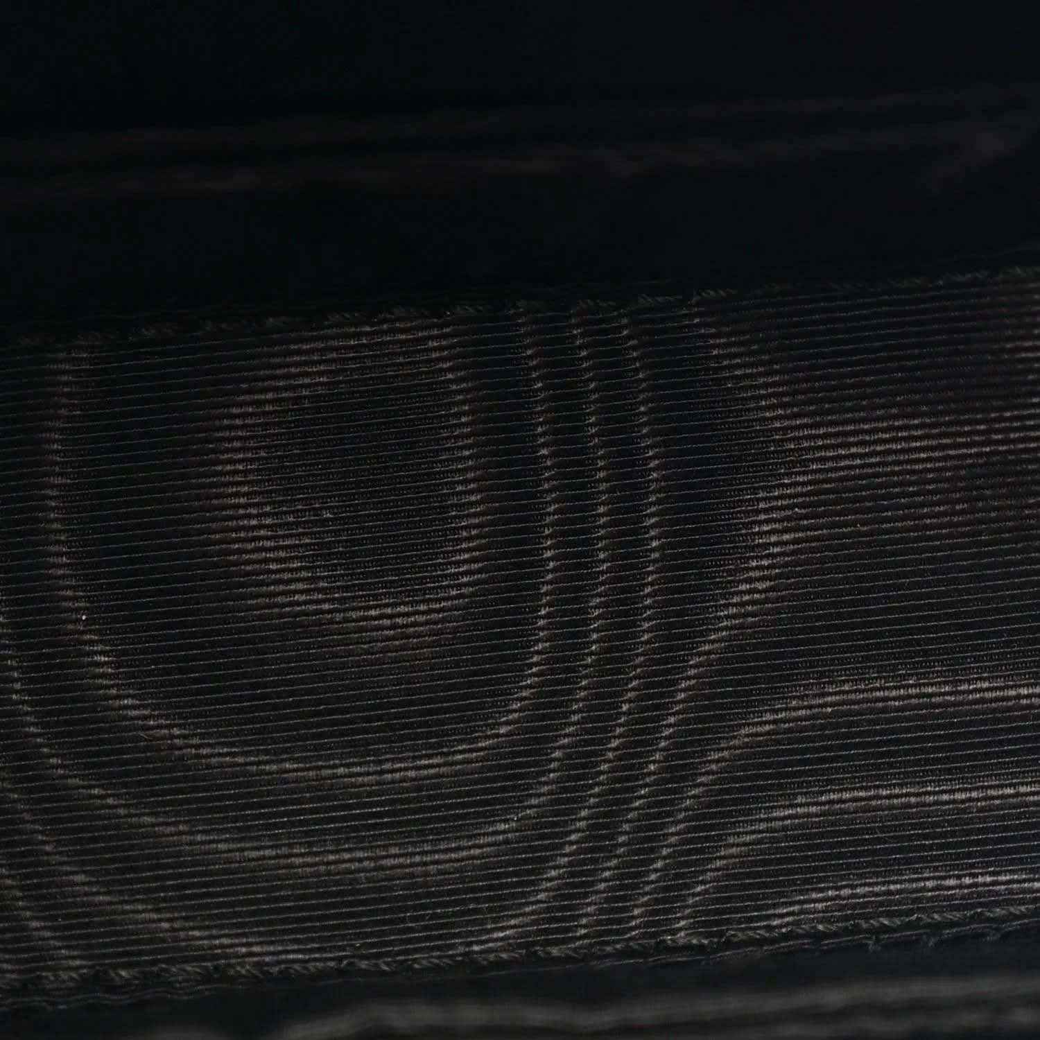 Close-up of black textured leather on mini bag exterior