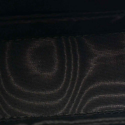 Close-up of black textured leather on mini bag exterior