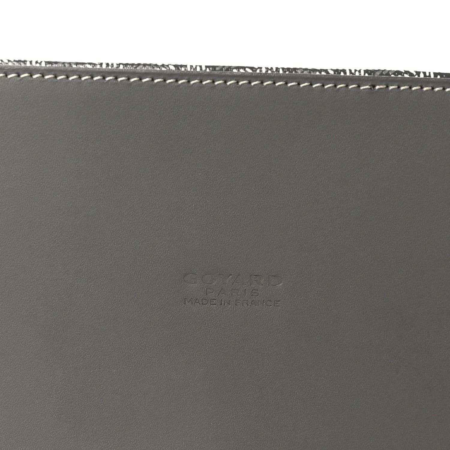 Grey leather handbag base with white stitching and subtle embossed maker text.