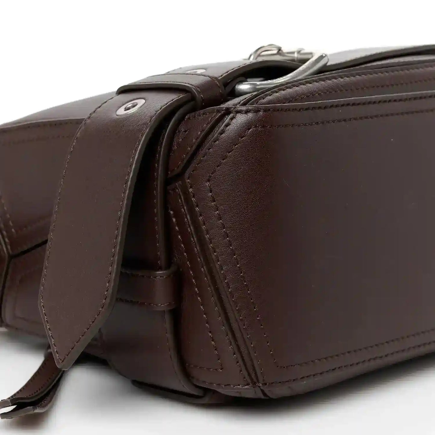 Side profile of small leather biker bag with zip hardware and crossbody strap in dark brown