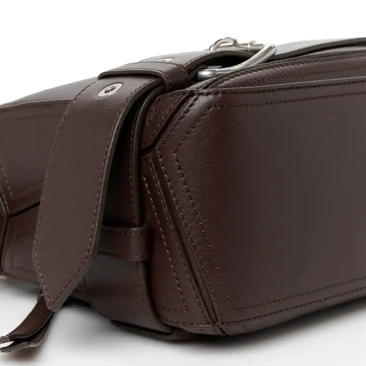 Side profile of small leather biker bag with zip hardware and crossbody strap in dark brown
