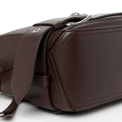 Side profile of small leather biker bag with zip hardware and crossbody strap in dark brown