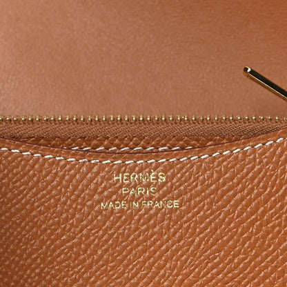 Constance slim wallet close-up showing zipper and embossed marks on tan leather