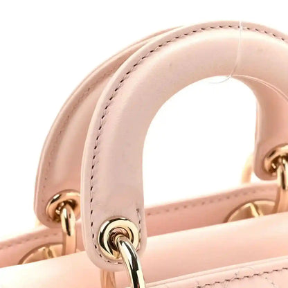 Powder pink lambskin bag handle with gold-tone clasp and stitched edging