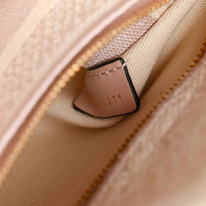 Rose-pink handbag interior seam with stitched pocket edge and zipper pull detail