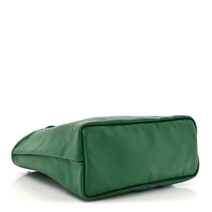 Green smooth reversible tote bag laid on its side with rounded rectangular shape