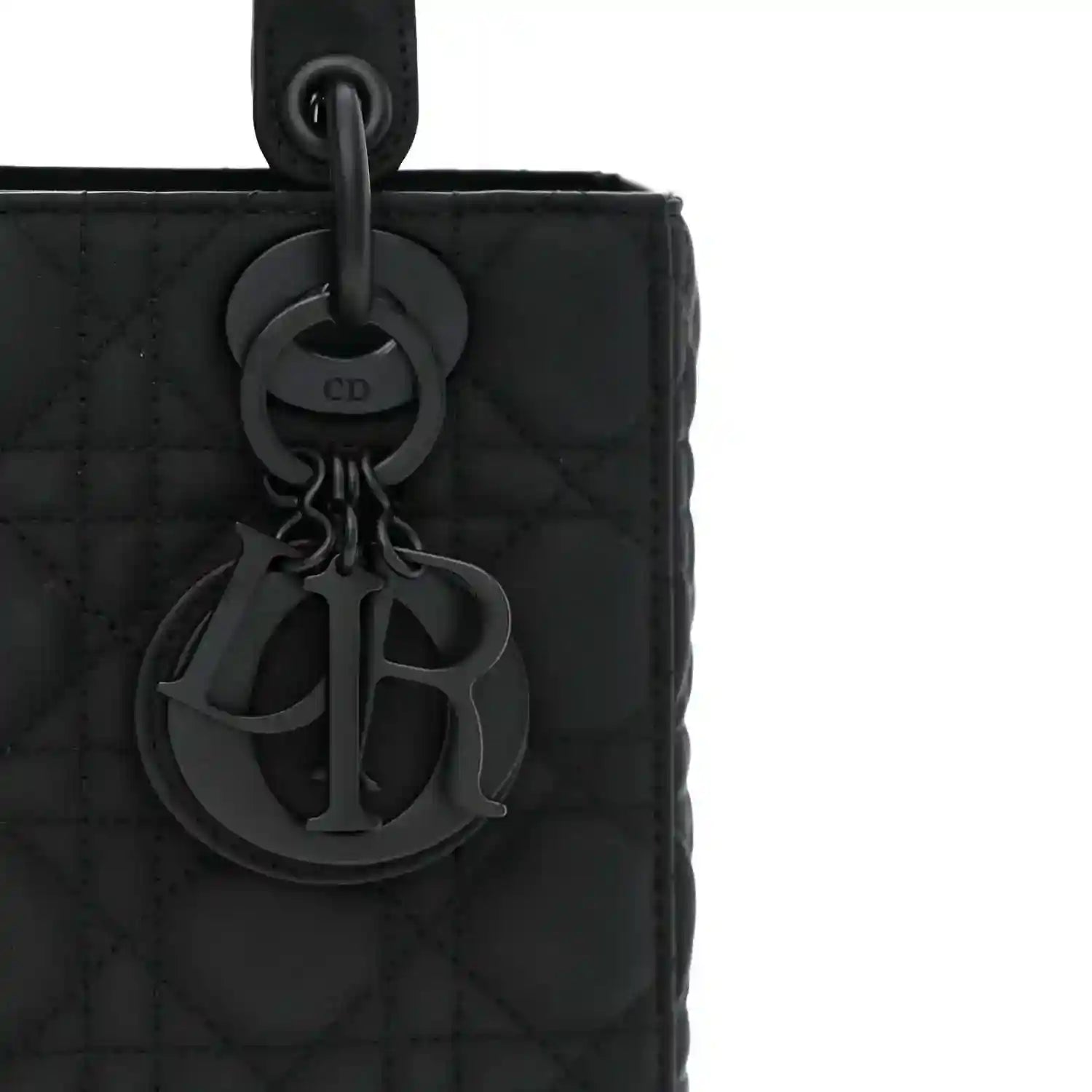 CD charm detail on a black quilted handbag front with ring handle attachment
