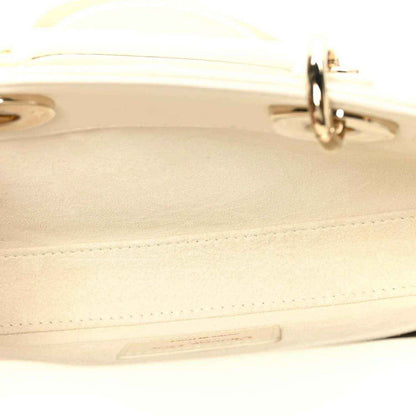 White handbag edge detail with stitched seam and gold-tone clasp hardware