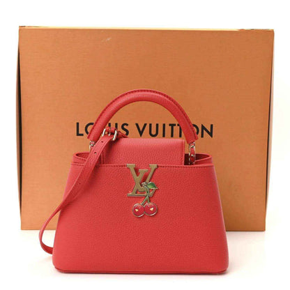 Red leather mini handbag with LV cherry charm, top handles, and included dust bag.