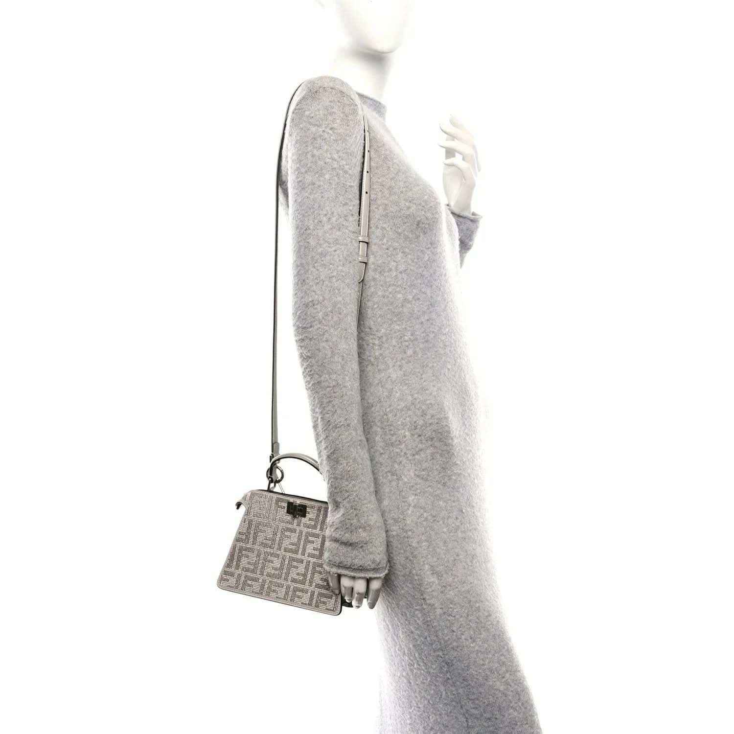 Small satchel side view with adjustable strap and mini front logo panel