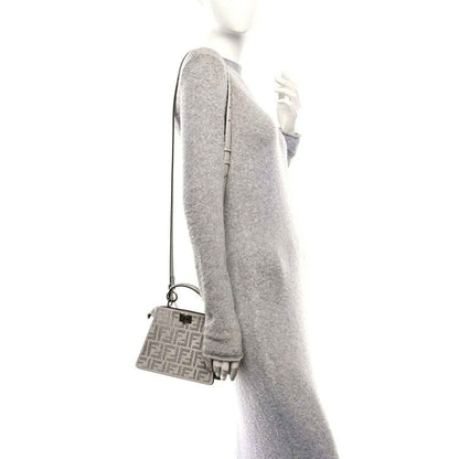 Small satchel side view with adjustable strap and mini front logo panel