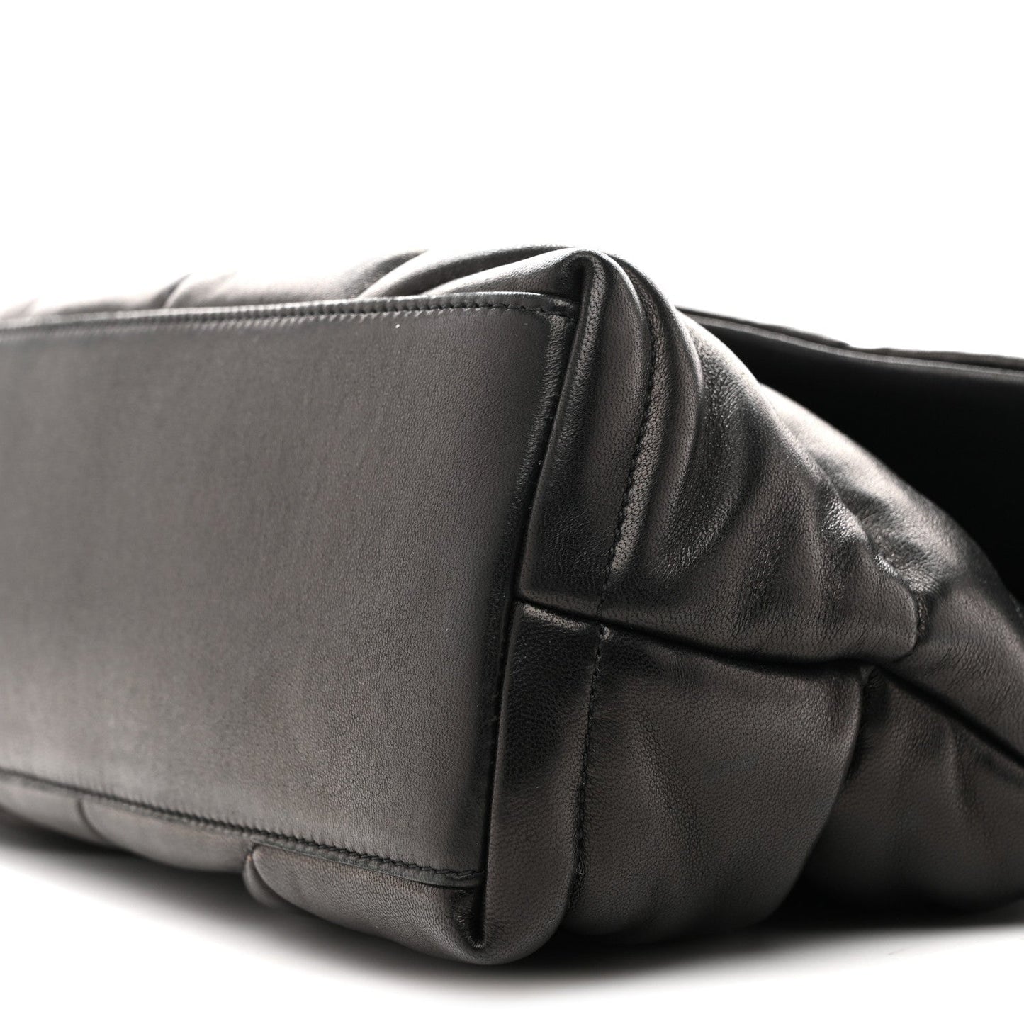 Black quilted puffer satchel side with stitched leather panel and edge