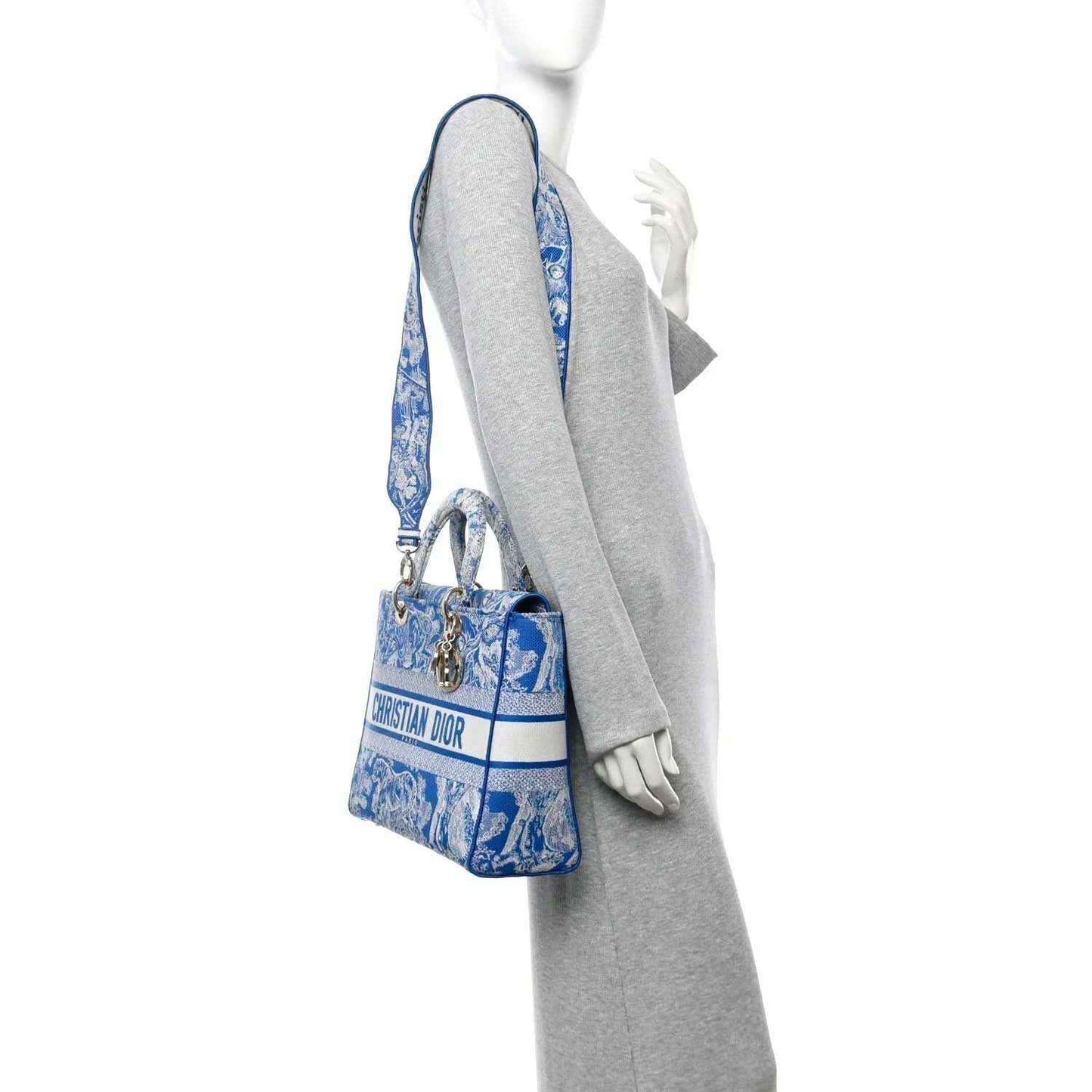 Blue embroidered Dior tote bag shown in side view with crossbody strap.