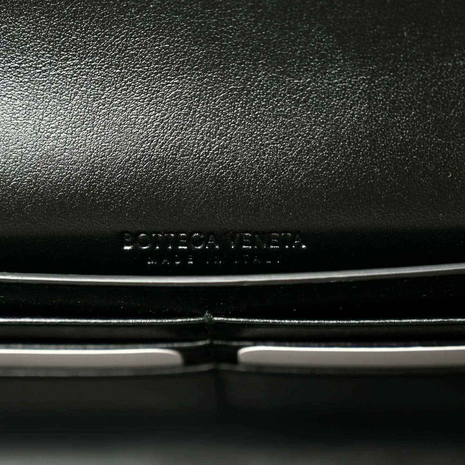 Black leather clutch exterior with embossed Bottega Veneta logo