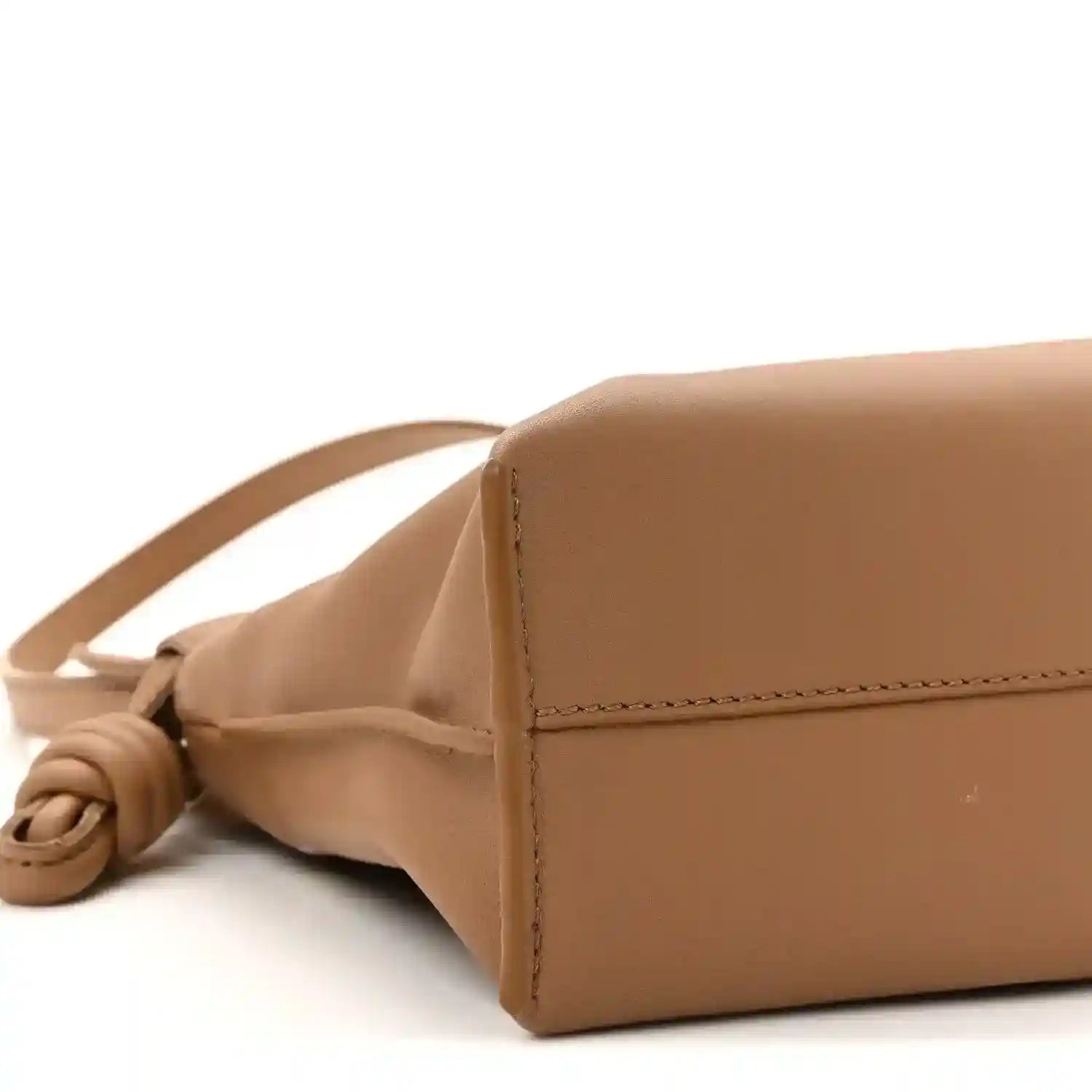 Tan mini clutch side detail with knotted leather cord strap.