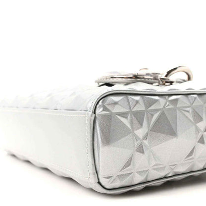 Small metallic silver handbag with geometric canage texture and metal top ring hardware.
