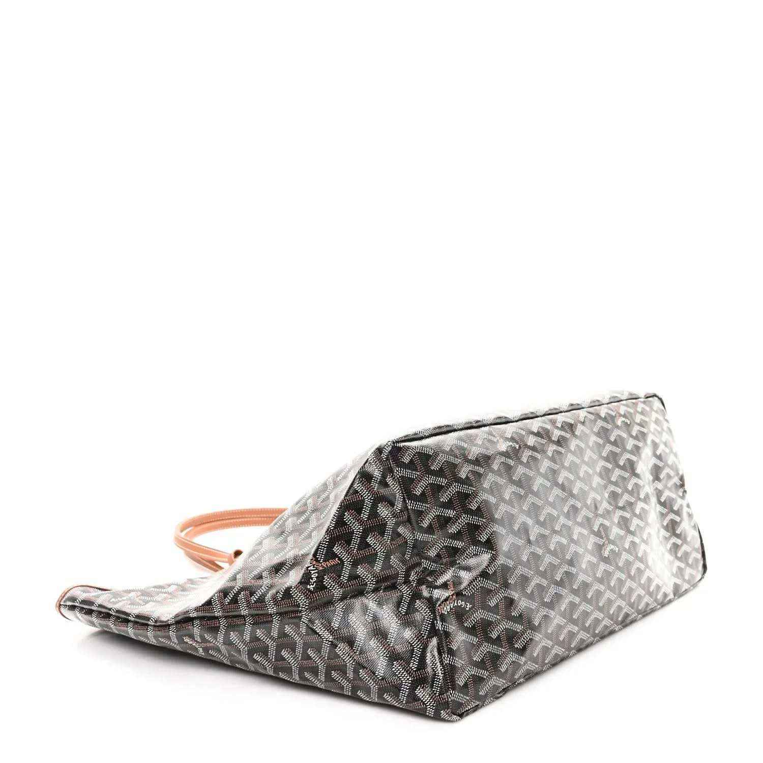 Black monogram zip pouch with tan wrist strap and patterned fabric