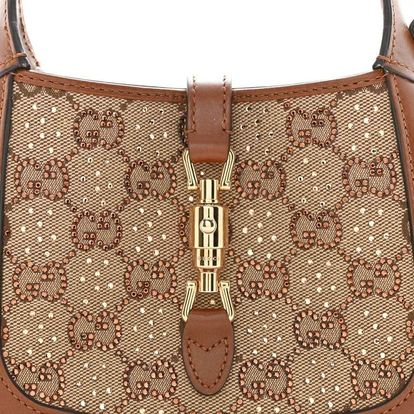 Mini hobo bag front close-up, beige GG monogram canvas with gold-toned clasp detail