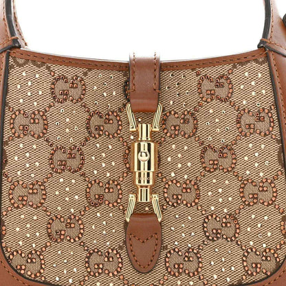 Mini hobo bag front close-up, beige GG monogram canvas with gold-toned clasp detail