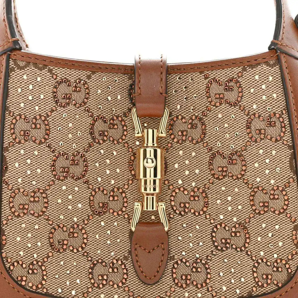 Mini hobo bag front close-up, beige GG monogram canvas with gold-toned clasp detail