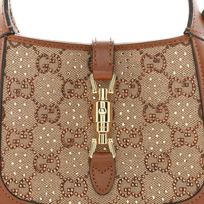 Mini hobo bag front close-up, beige GG monogram canvas with gold-toned clasp detail