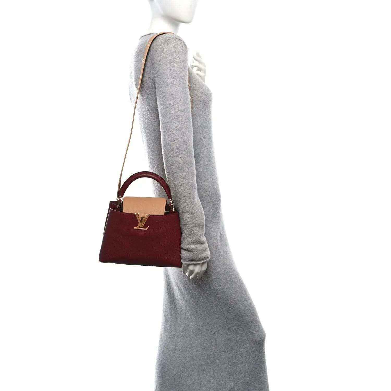 Bordeaux mini handbag with tan top handle and crossbody strap, worn at side.
