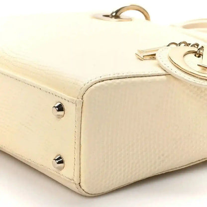 Ivory lizard mini handbag corner with gold studs and top handle base