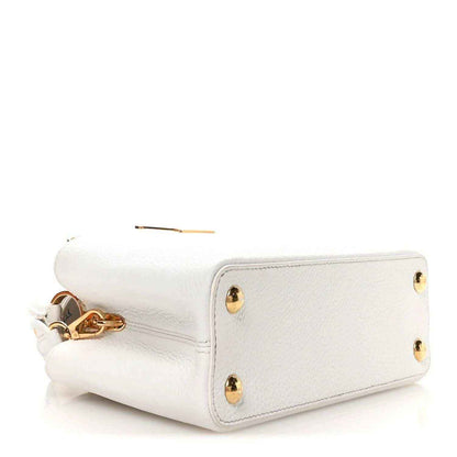 White leather baguette-style handbag with gold-tone studs and side chain detail