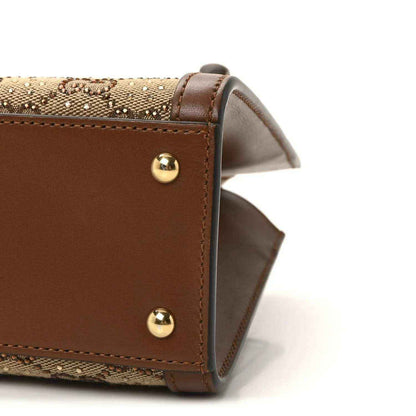 Gucci mini tote bag corner view, brown leather with gold studs and tan monogram canvas