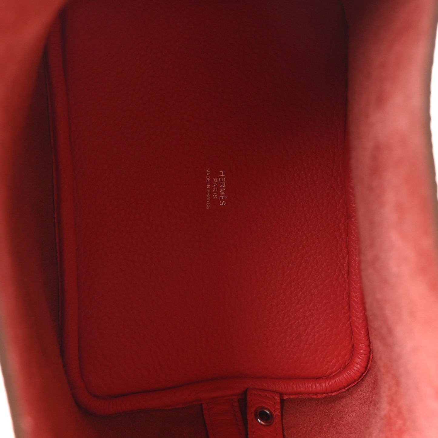 Red leather interior panel with embossed brand stamp near inner pocket