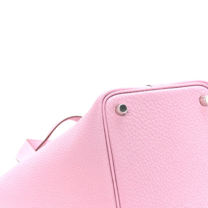 Rose pink leather handbag close-up of top corner with metal snap stud