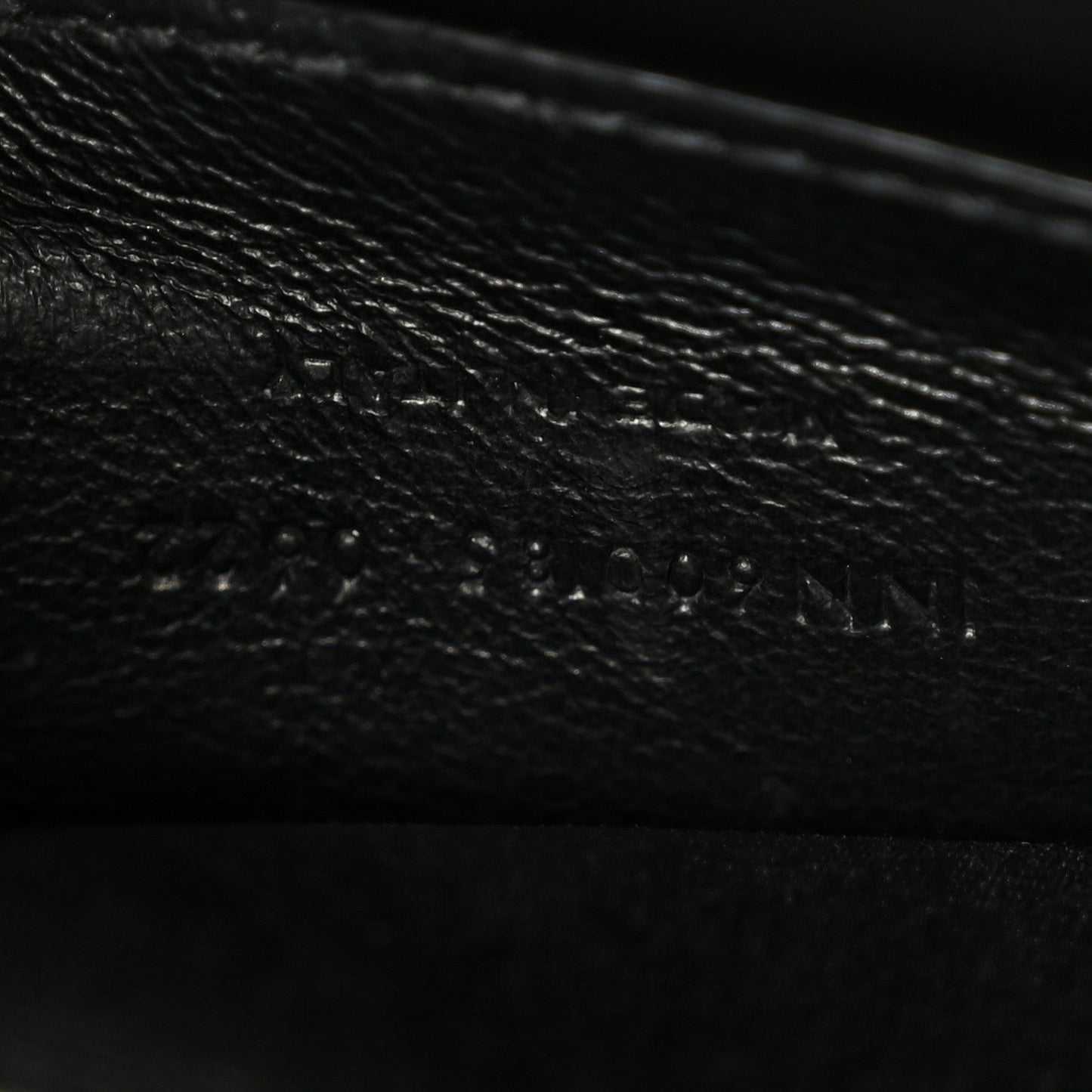 Leather satchel interior panel detail in dark color, textured grain and stitching