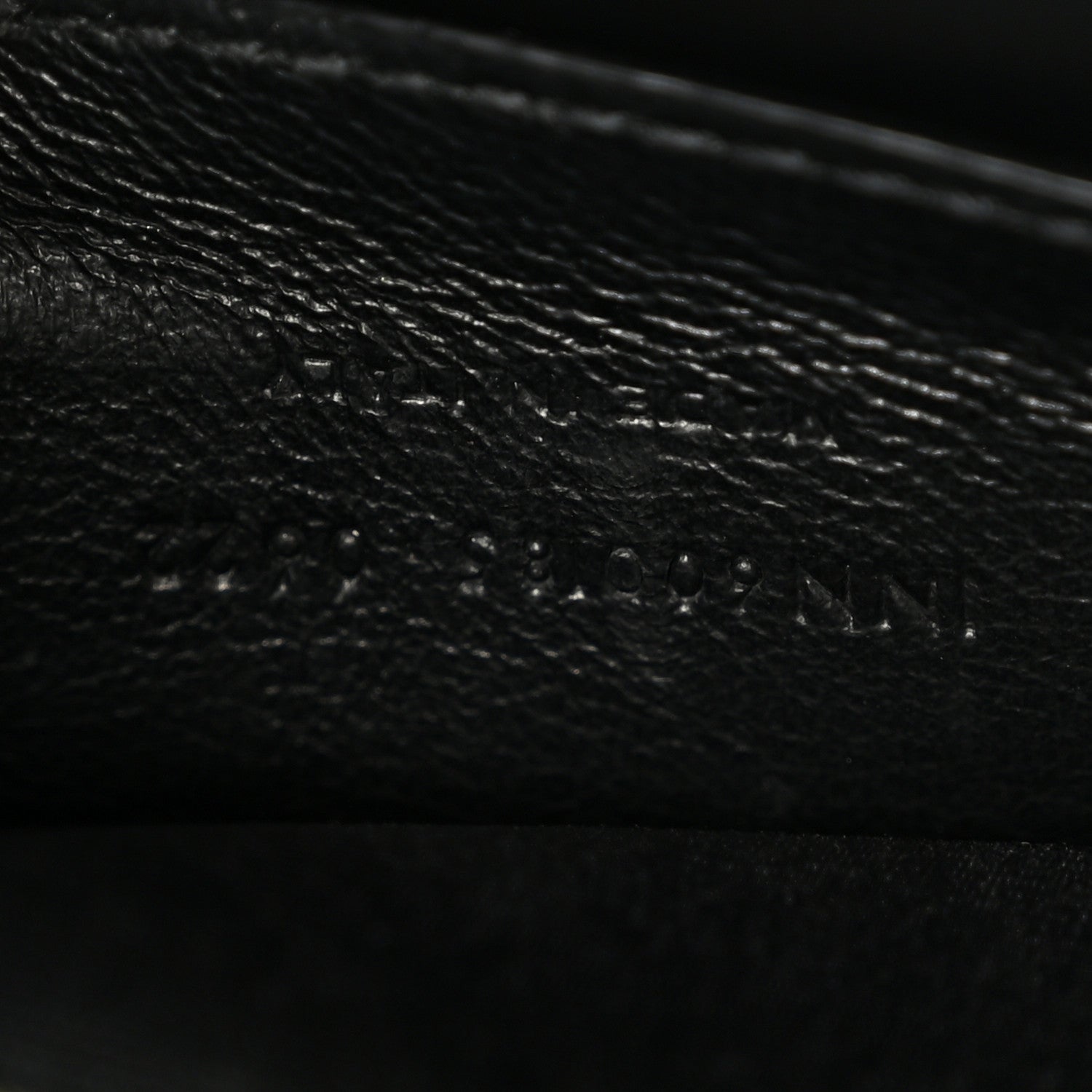 Leather satchel interior panel detail in dark color, textured grain and stitching