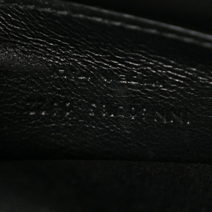 Leather satchel interior panel detail in dark color, textured grain and stitching