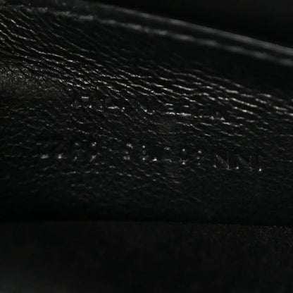 Leather satchel interior panel detail in dark color, textured grain and stitching