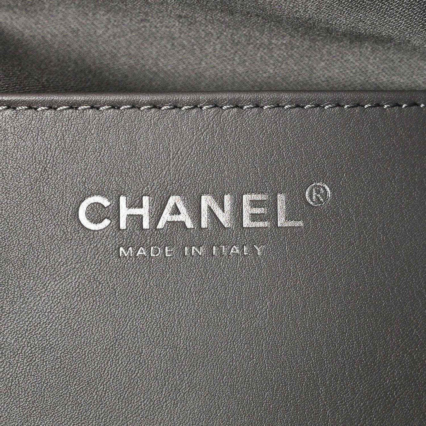 Chanel logo patch reading CHANEL and MADE IN ITALY on dark leather