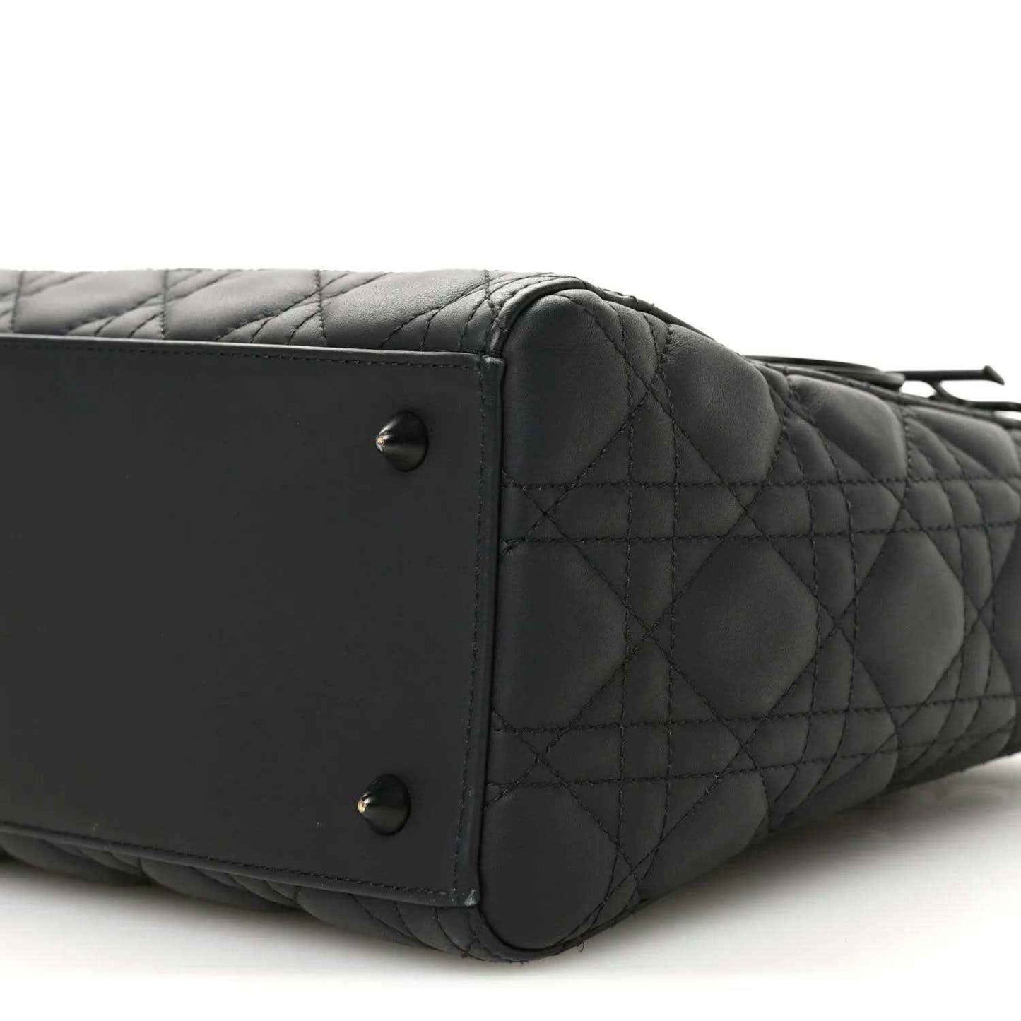 Black quilted Lady Dior bag side close-up with rivets and stitched leather panel