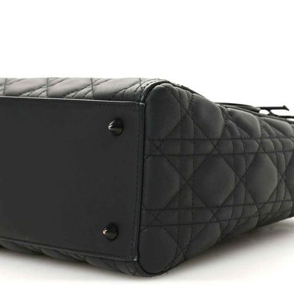 Black quilted Lady Dior bag side close-up with rivets and stitched leather panel