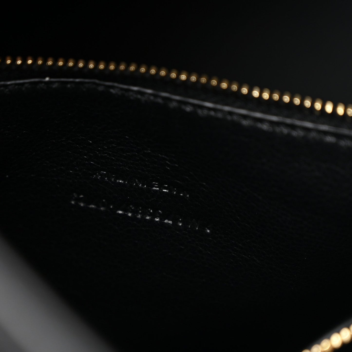 Black leather hobo bag interior detail with gold chain edging and stitching