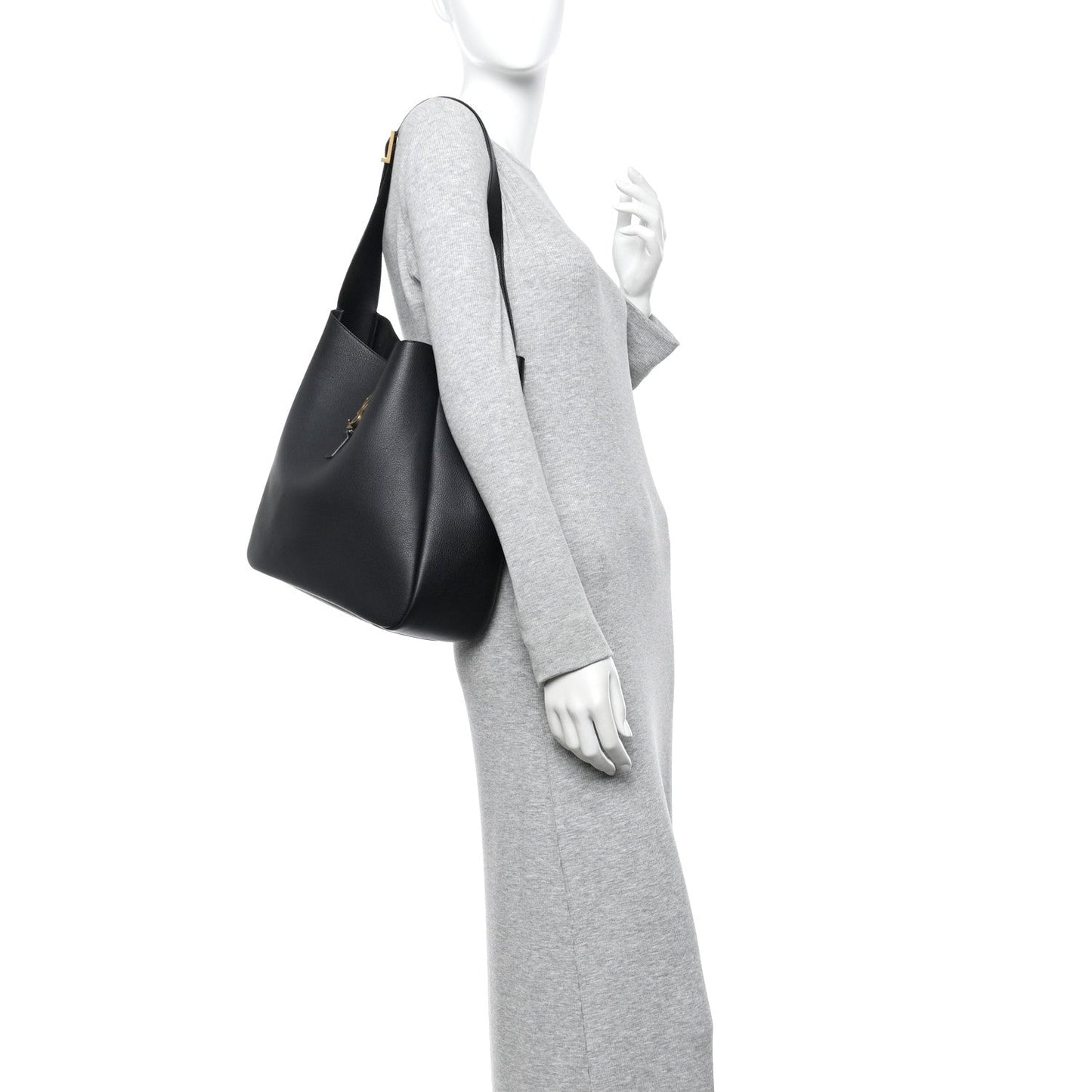 Black leather soft hobo bag worn on shoulder over a gray long-sleeve dress