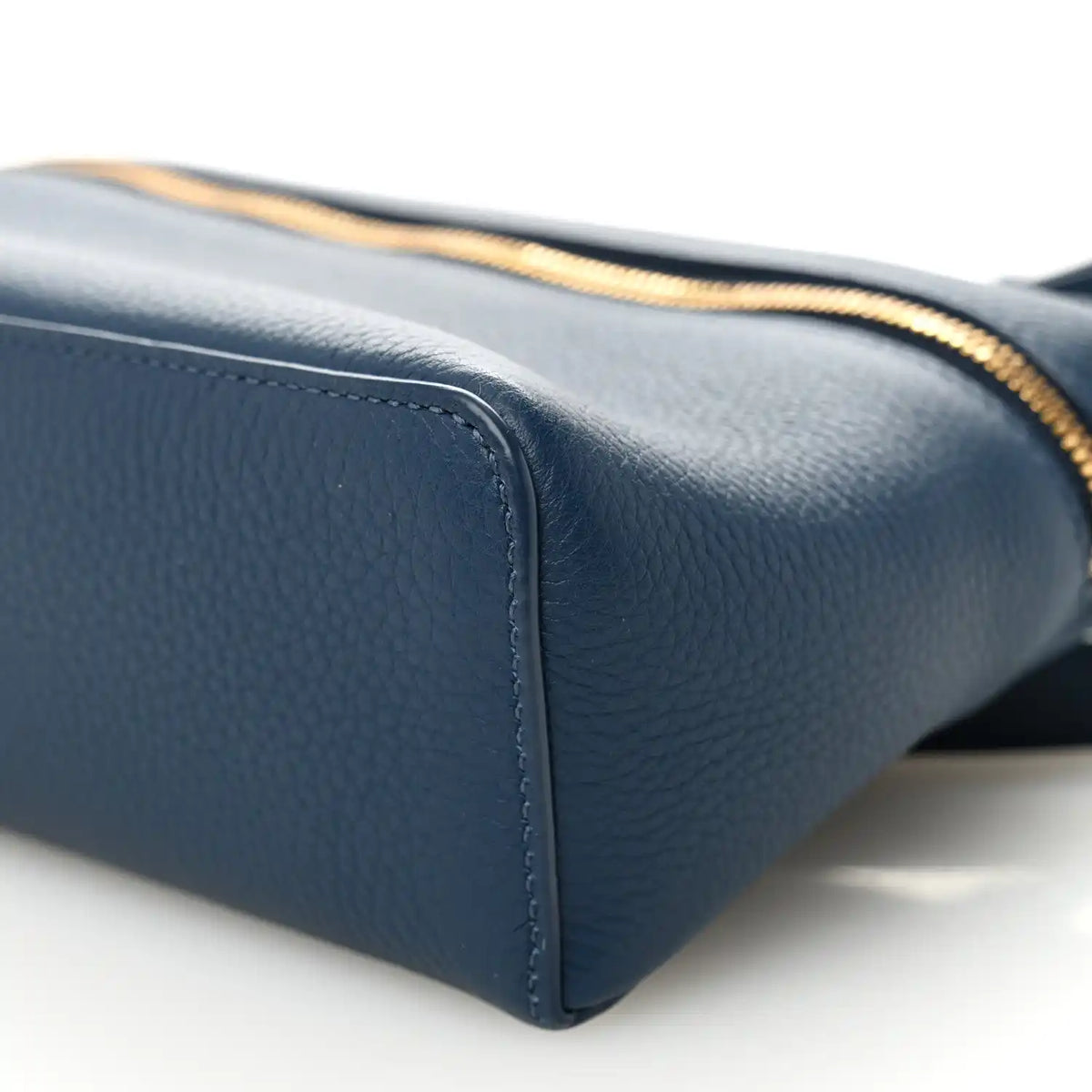 Navy grained calfskin pouch base corner with gold zipper trim
