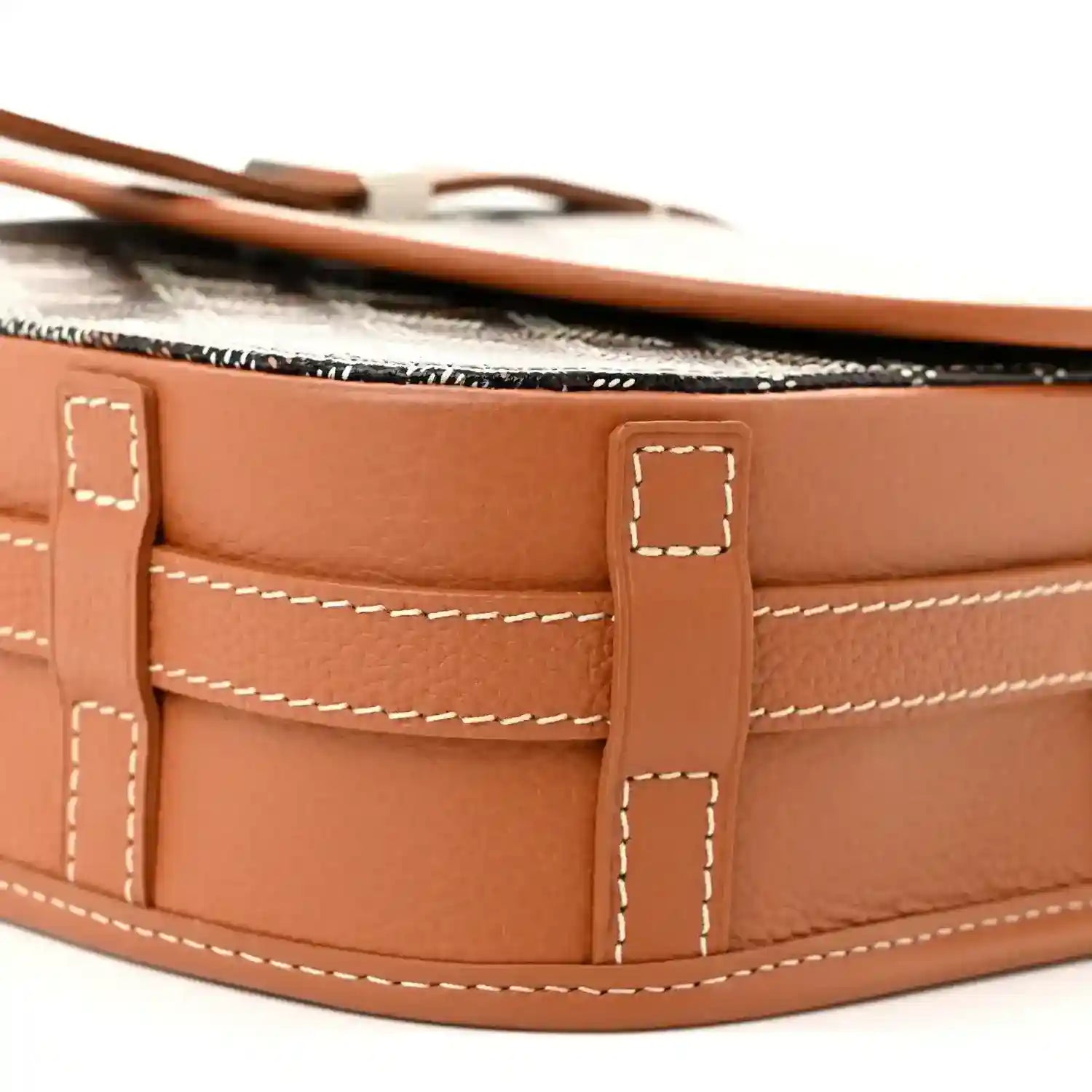 Tan leather inner pocket compartments with stitched seams inside the messenger bag