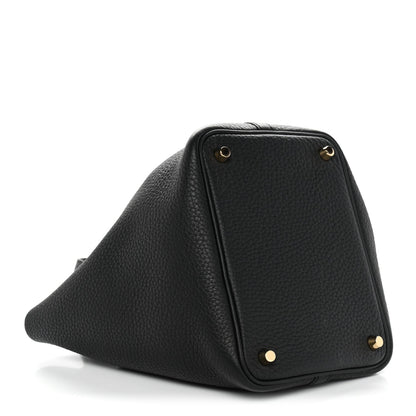 Black textured leather triangular tote with gold corner hardware