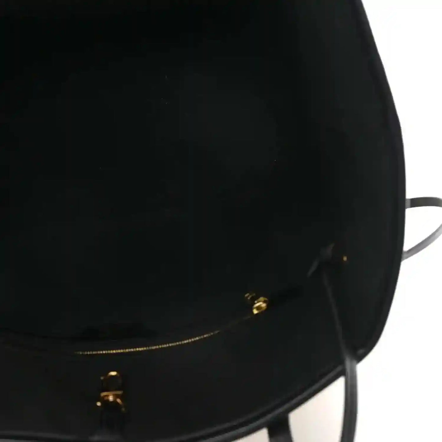 Black bag opening with gold-tone zipper hardware and pull tab