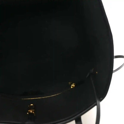 Black bag opening with gold-tone zipper hardware and pull tab