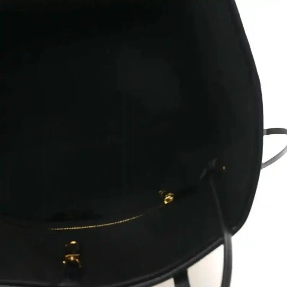 Black bag opening with gold-tone zipper hardware and pull tab