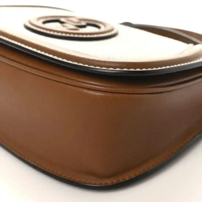 Brown leather top edge with beige canvas trim and stitched border