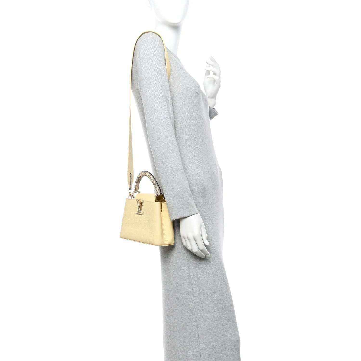 Cream mini handbag with shoulder strap, gold hardware, and compact rectangular shape.