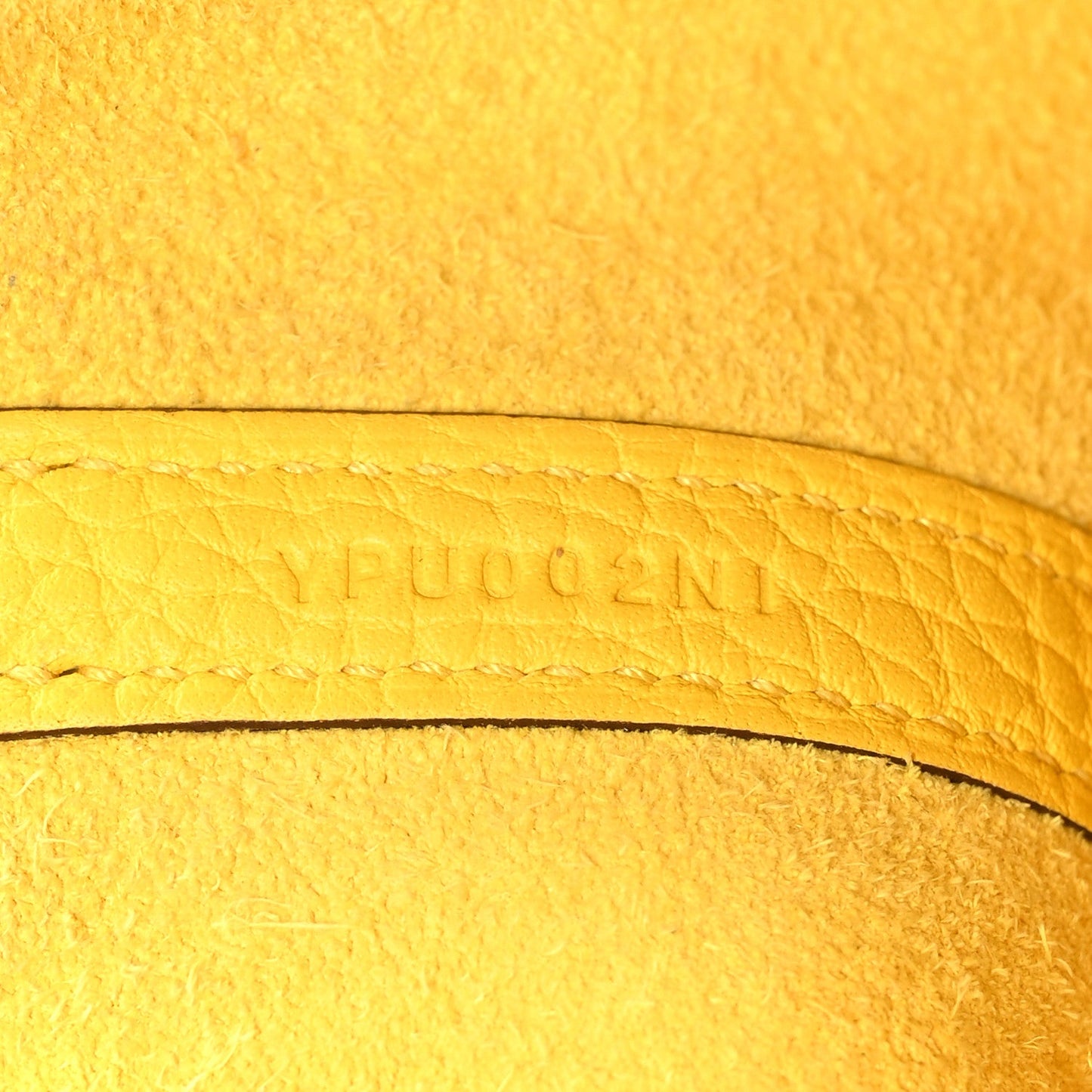 Lime yellow leather with embossed lettering along curved edge