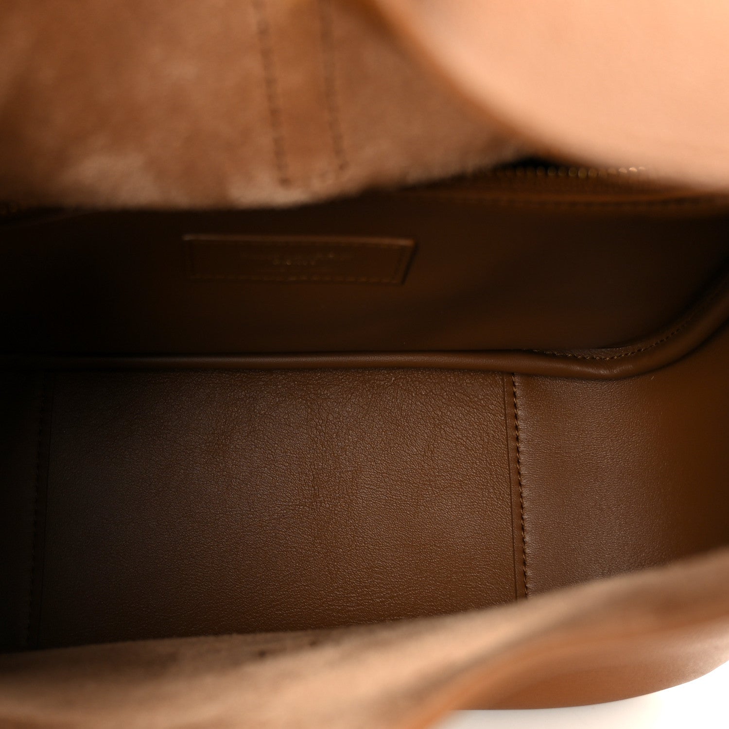Saint Laurent hobo bag interior view with brown leather lining and stitched edge